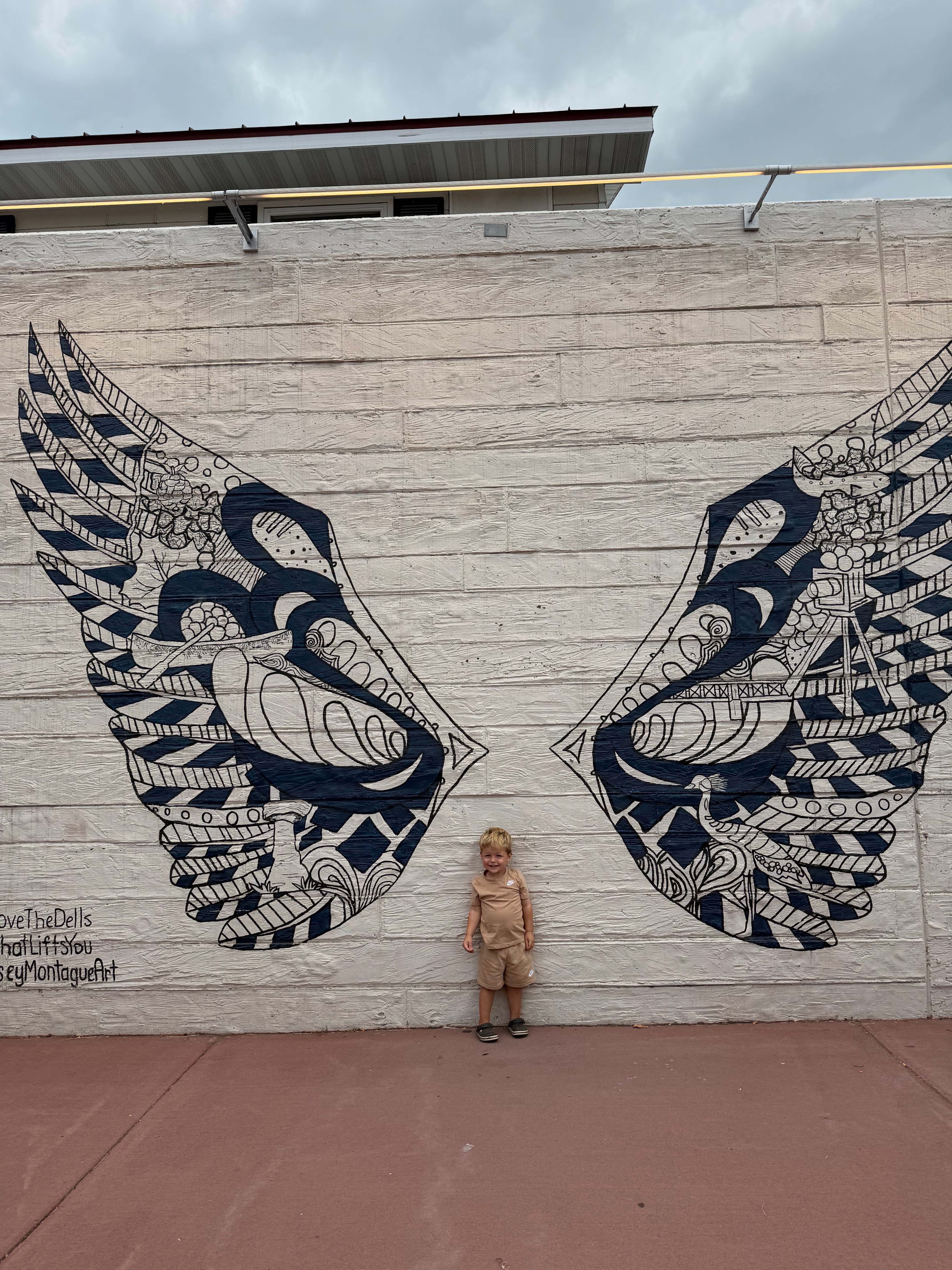 Child standing in front of the detailed Elm Street Plaza mural