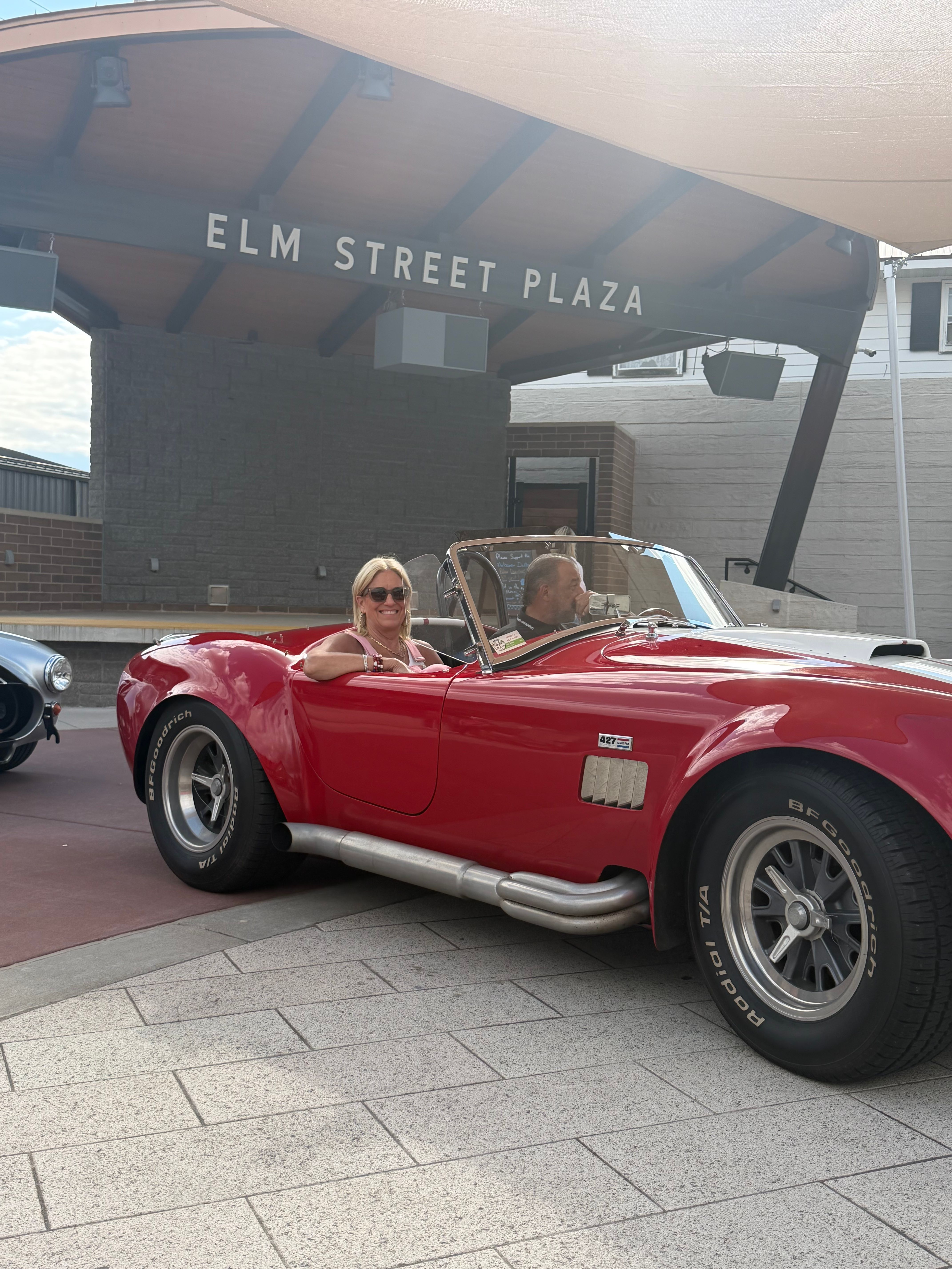 Red classic roadster displayed at Elm Street Plaza