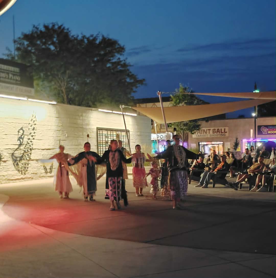 Traditional dancers performing for an evening crowd at Elm Street Plaza
