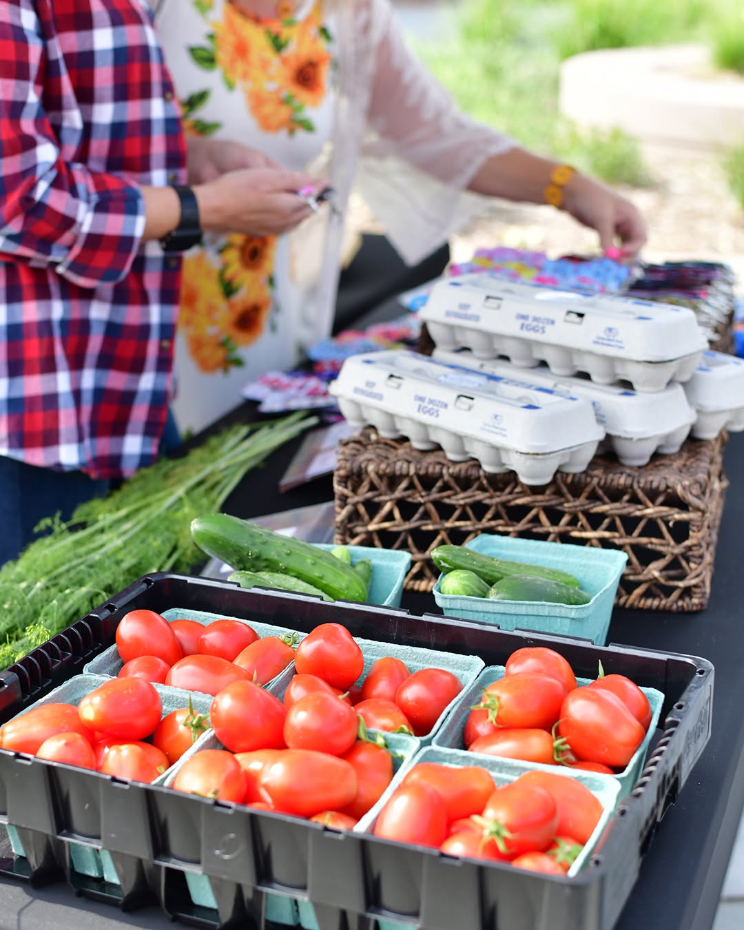Shoppers browsing fresh produce and eggs at the farmers market