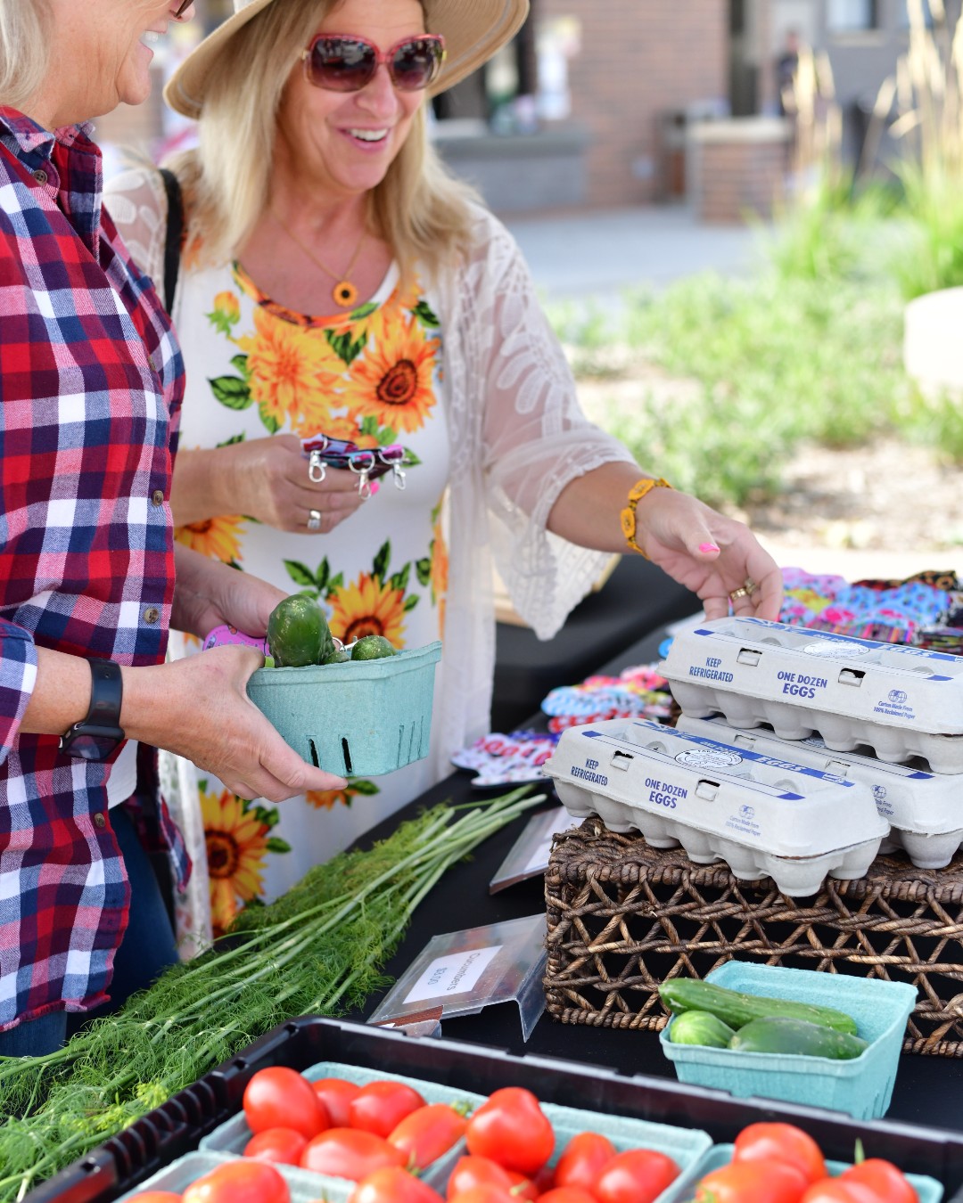 Shoppers browsing fresh produce and eggs at the farmers market
