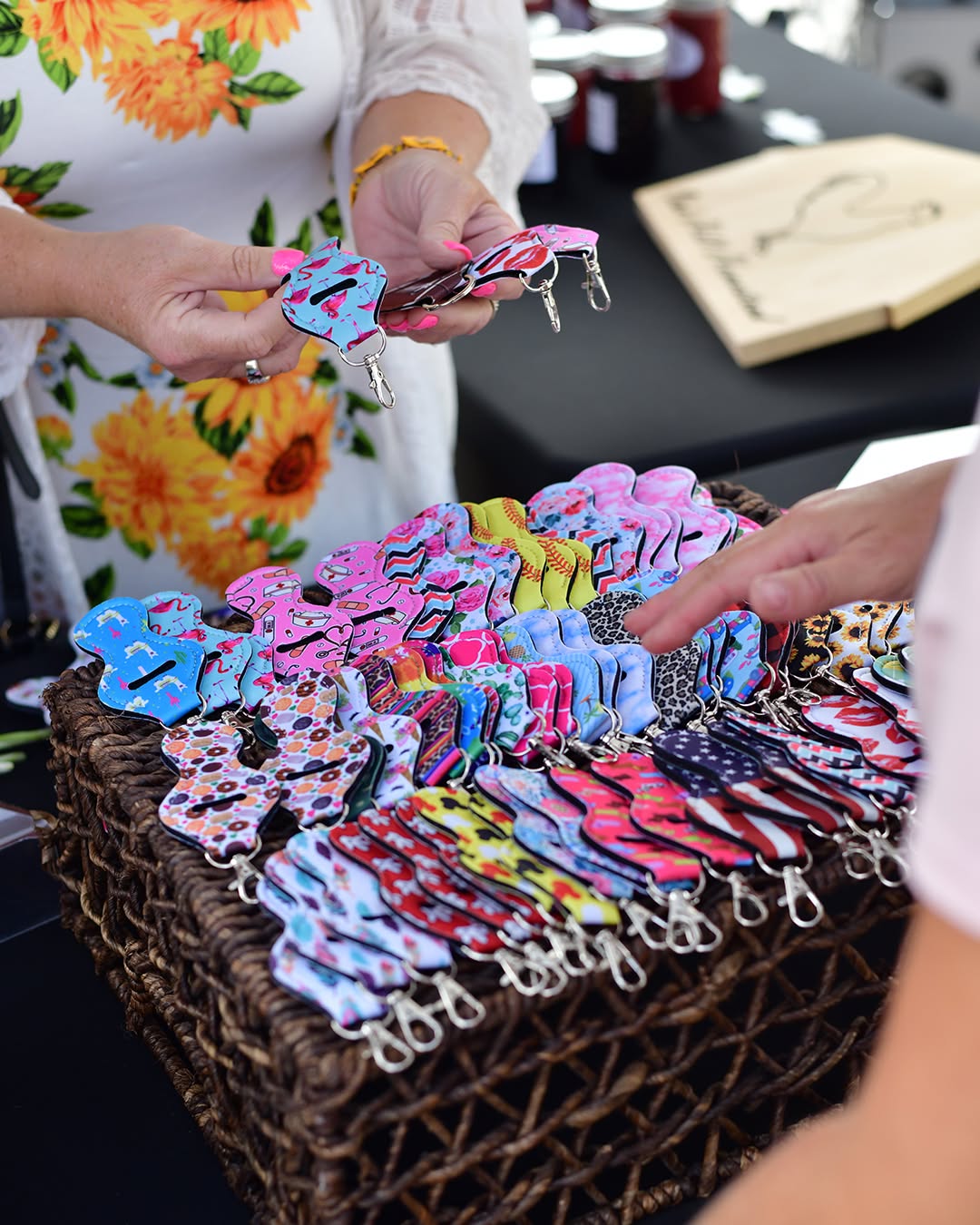 Colorful handmade keychains in a woven basket at a vendor booth