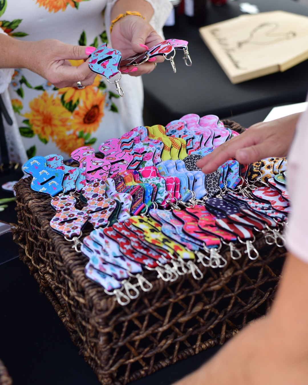Colorful handmade keychains in a woven basket at a vendor booth