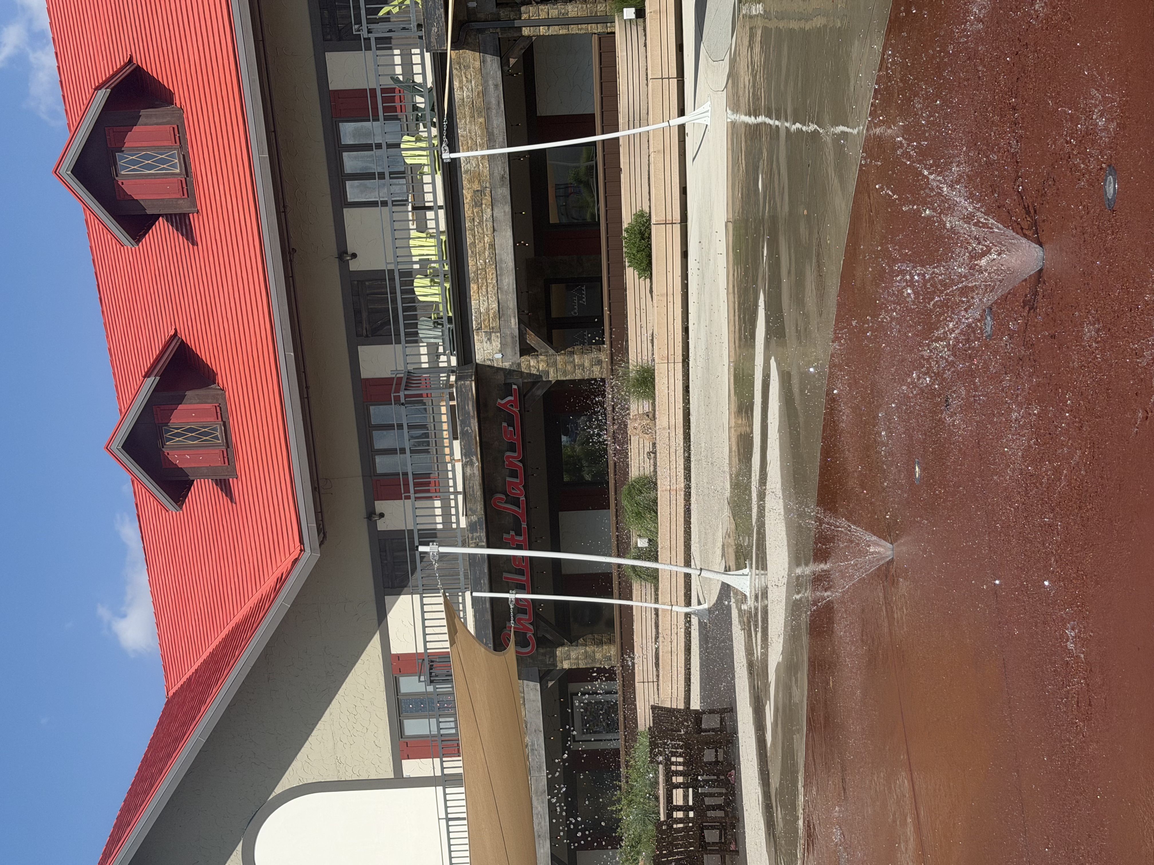 Water fountains spraying in front of Chalet Lanes at Elm Street Plaza
