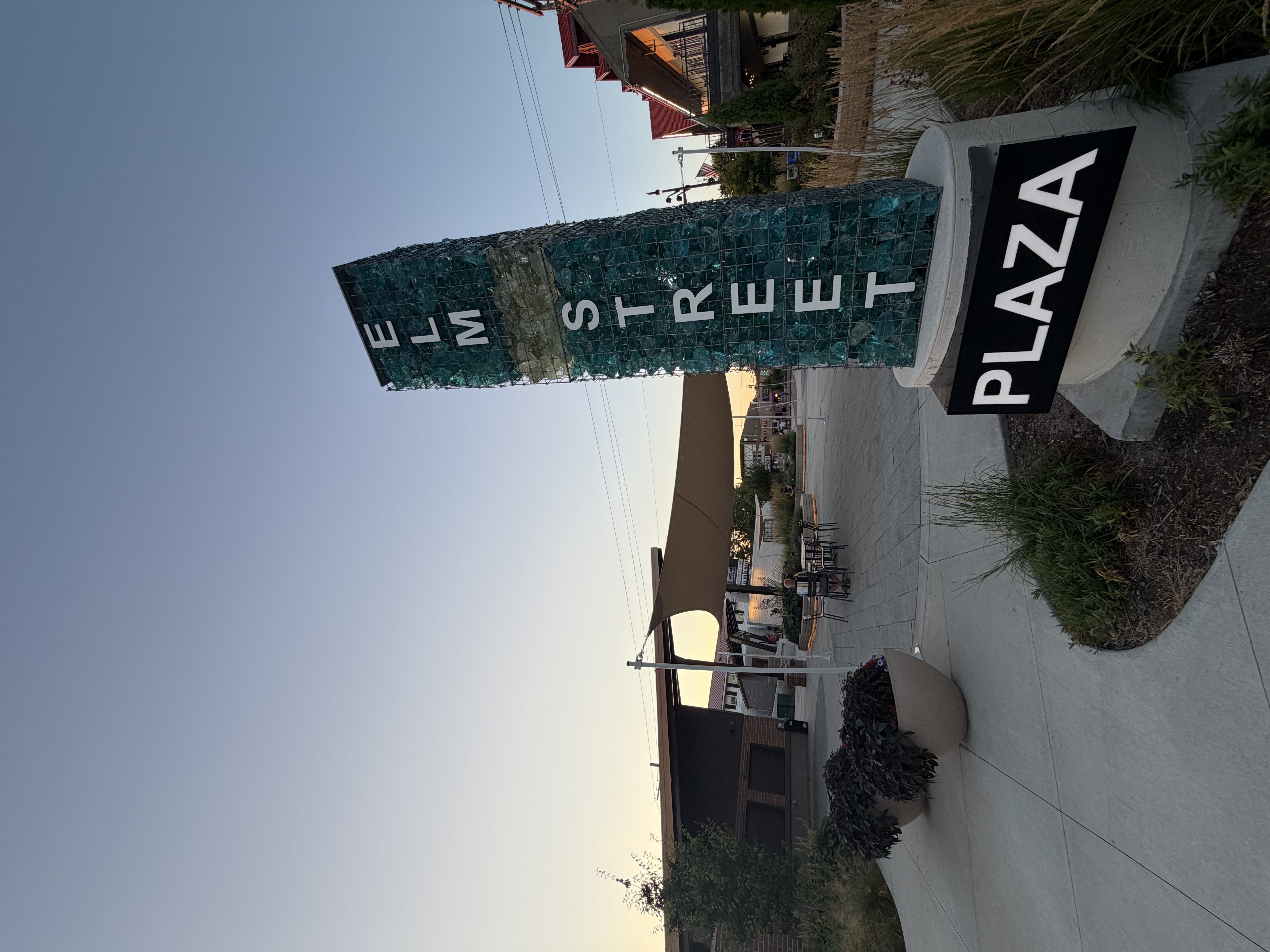 Landscaped Elm Street Plaza gathering space in the evening